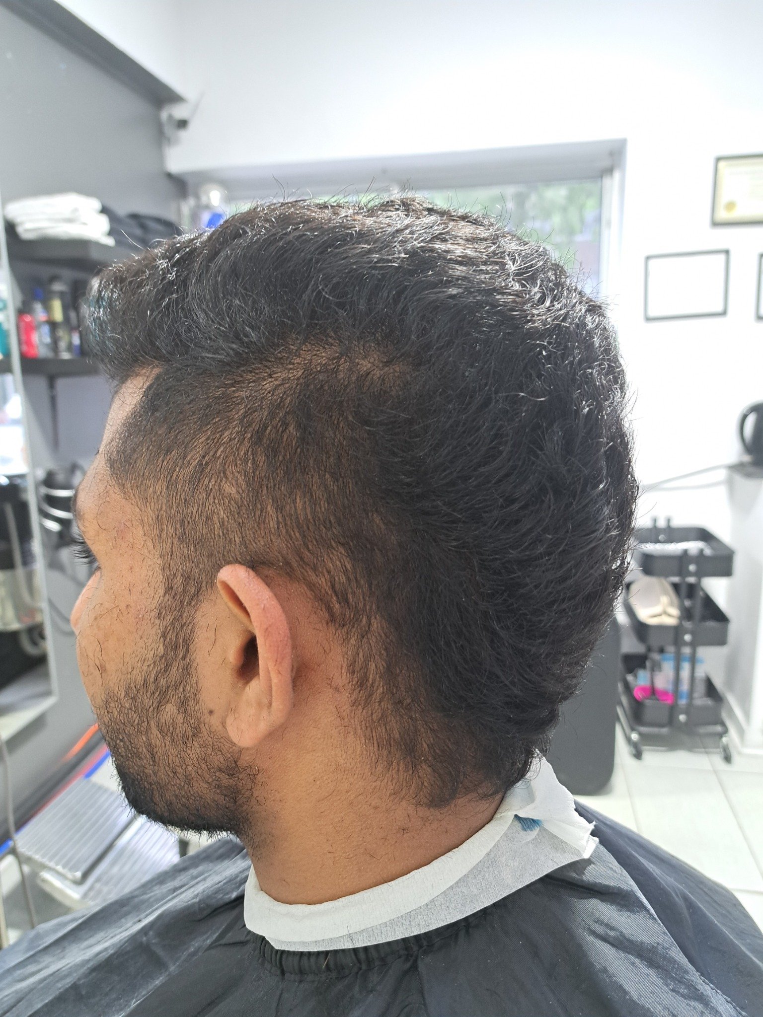 Men's fade haircut with textured dark hair by Konstantin Stylist